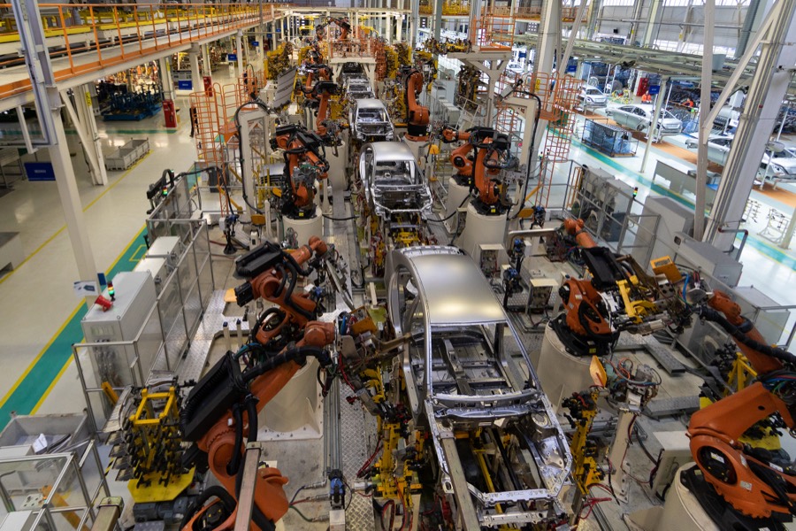 Automotive manufacturing assembly line with robotic arms